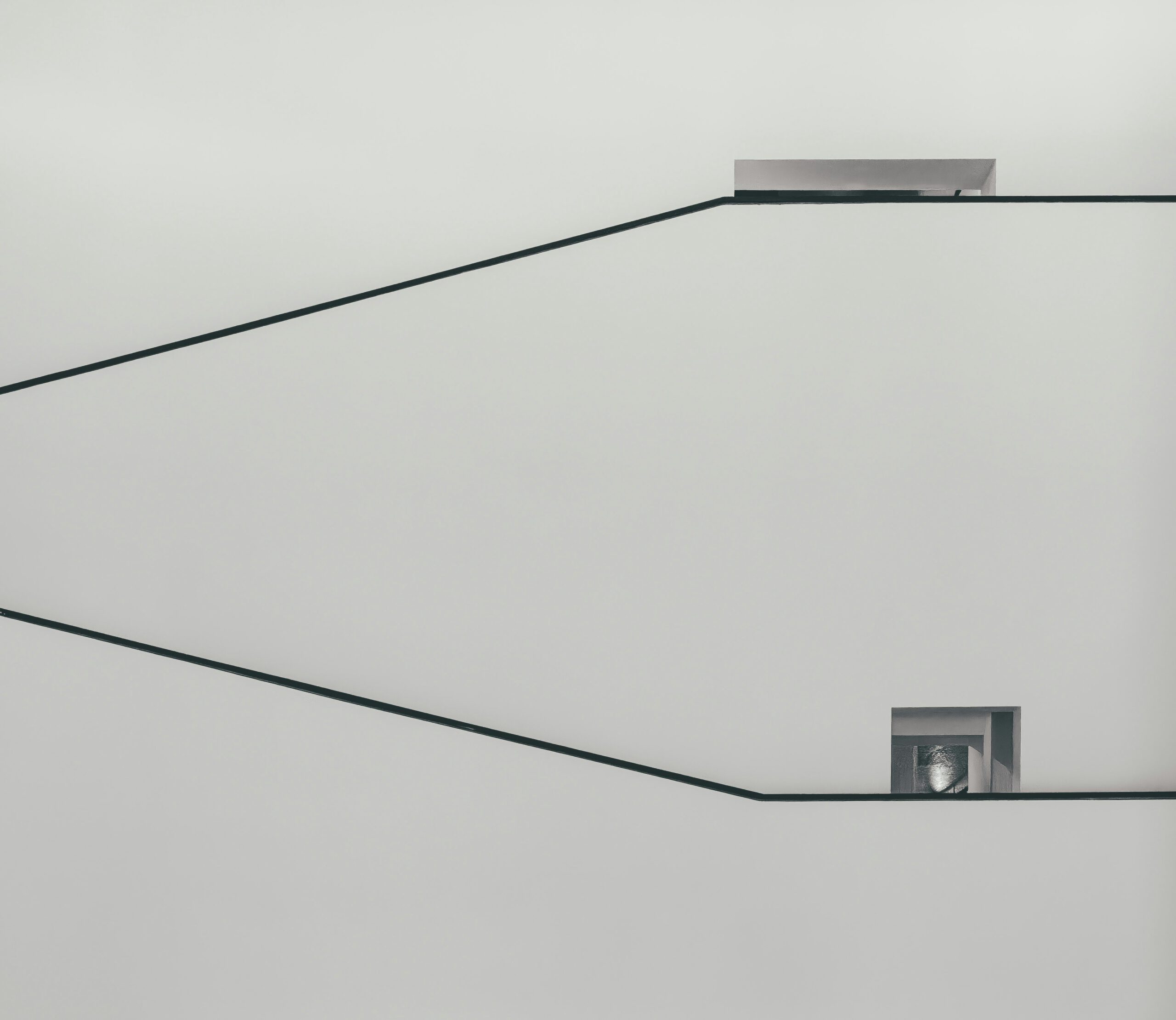 Minimalistischer Innenraum mit geometrischen Linien und kleinem Fenster – moderne Architektur und Designästhetik